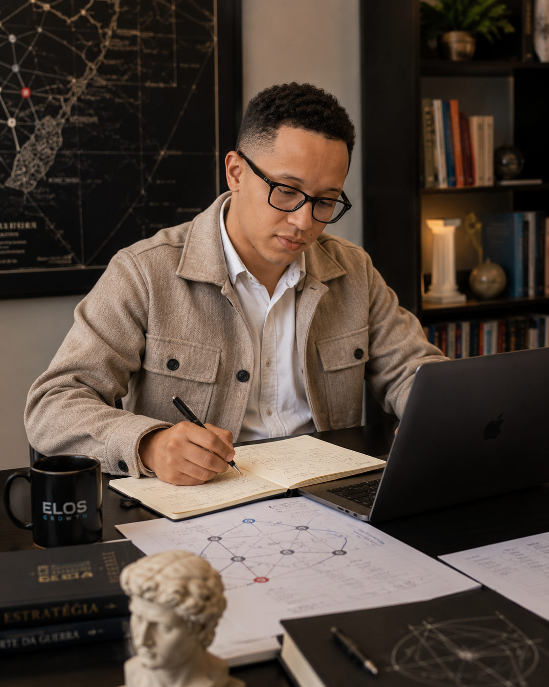 Matheus Souza, fundador da Elos Growth, escrevendo em um caderno de trabalho